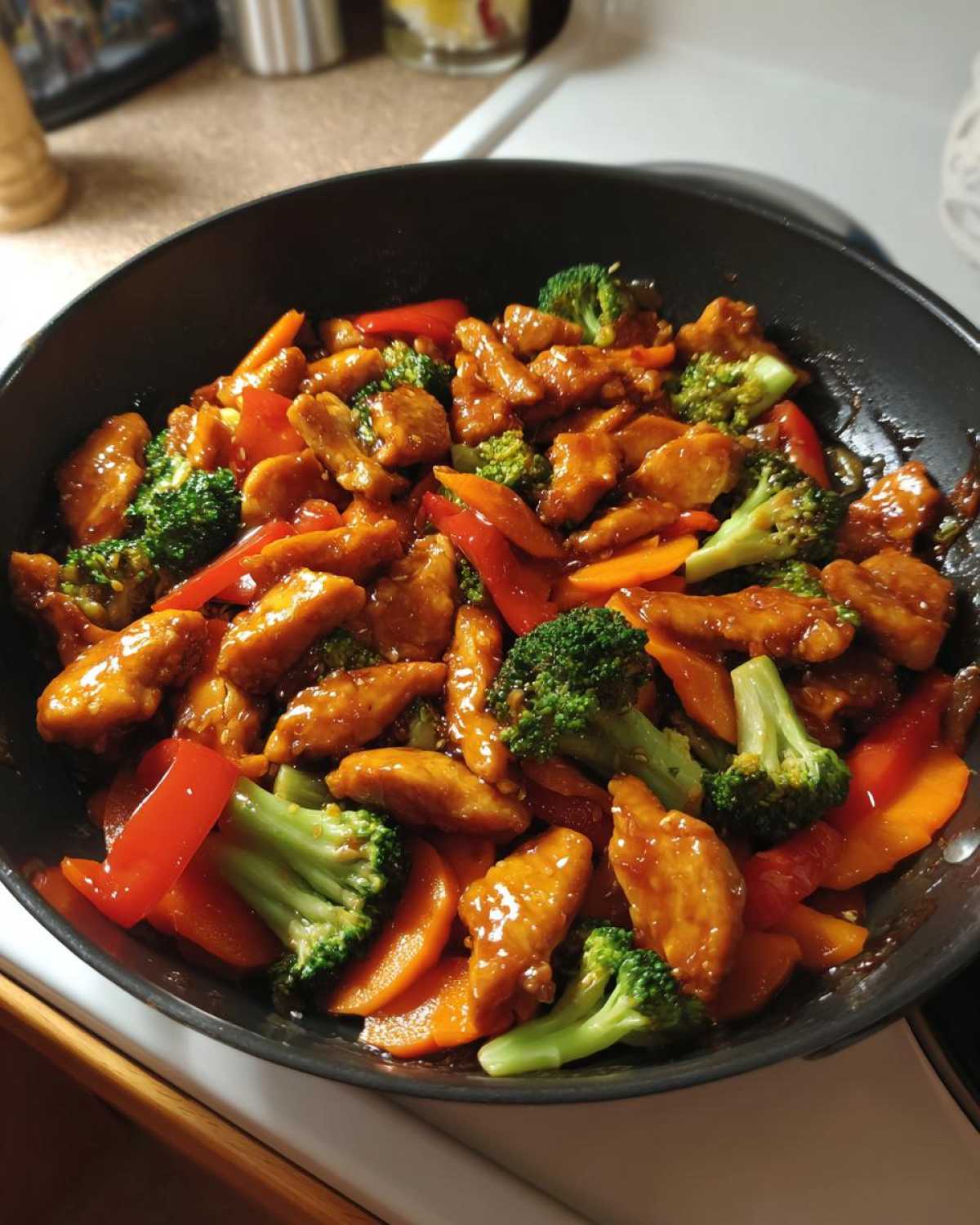 Close-up of Honey Soy Chicken Skillet with Veggies, featuring glazed chicken pieces, bright green broccoli, and sliced carrots and peppers in a black skillet.