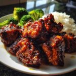 Close-up of glazed Sticky Teriyaki Chicken pieces served with white rice and steamed broccoli.