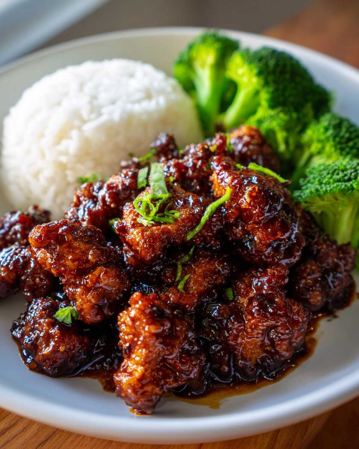 A plate featuring Sticky Teriyaki Chicken Easy coated in dark, glossy sauce, served with white rice and steamed broccoli.