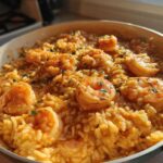 Close-up of a skillet filled with rich, creamy Cajun shrimp and rice, garnished with parsley.