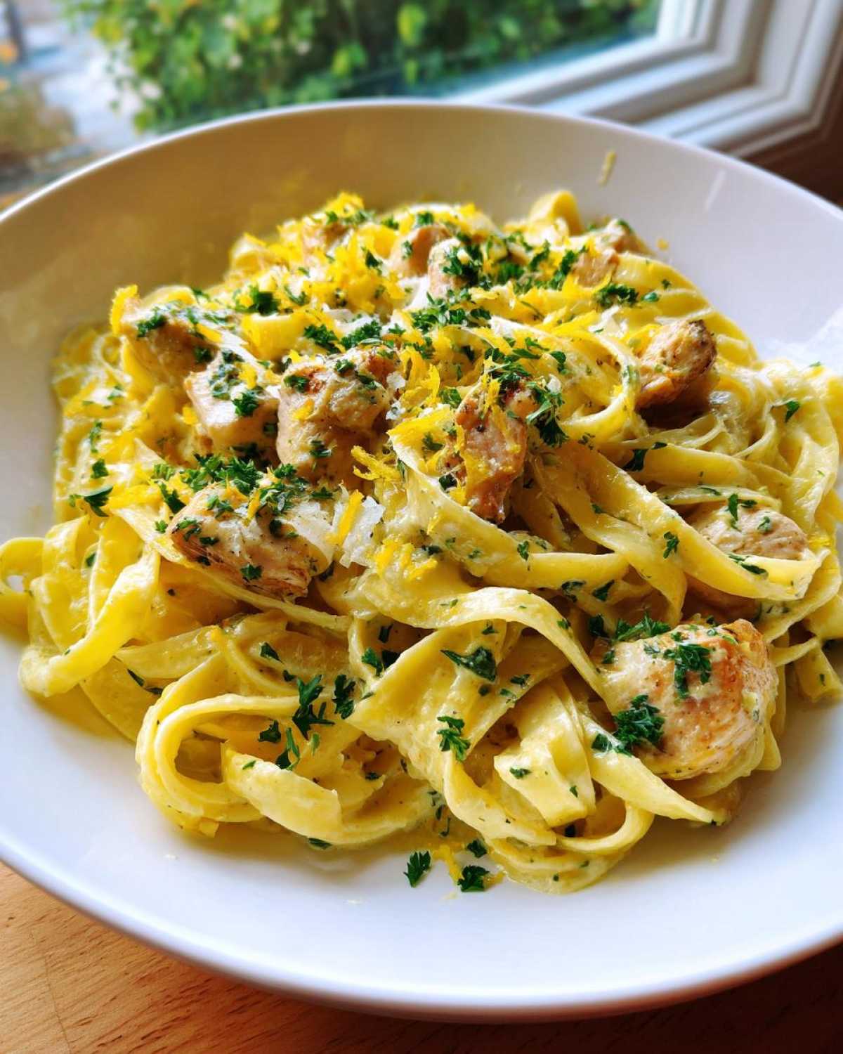 Close-up of Creamy Lemon Garlic Pasta with Chicken, topped with lemon zest and parsley.