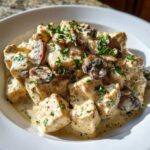 Close-up of tender chicken pieces in a rich, creamy mushroom sauce, garnished with fresh parsley. Creamy Mushroom Chicken Skillet Easy Dinner.