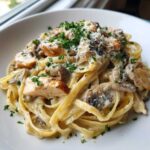 A close-up of rich Creamy Mushroom Garlic Pasta with Chicken, topped with Parmesan and parsley.