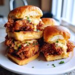 A tempting stack of Crispy Chicken Sliders with Garlic Sauce drizzled over the fried chicken.