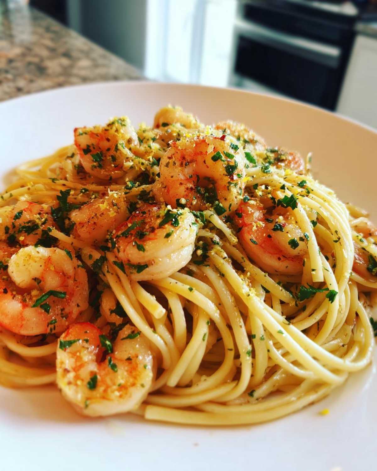 A close-up of delicious Garlic Butter Shrimp Pasta with Lemon Flavor, topped with parsley and zest.