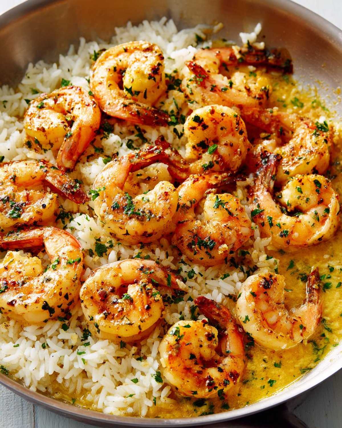 Close-up of perfectly cooked Garlic Butter Shrimp with Rice Skillet, glistening in a rich garlic butter sauce and topped with parsley.