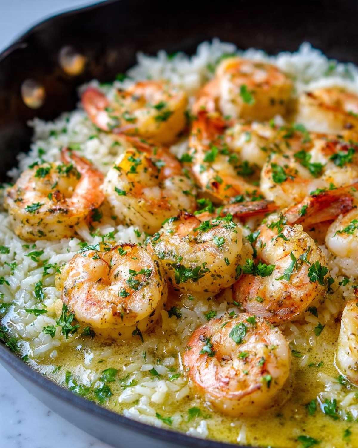 Close-up of juicy Garlic Butter Shrimp with Rice Skillet, topped with fresh parsley.