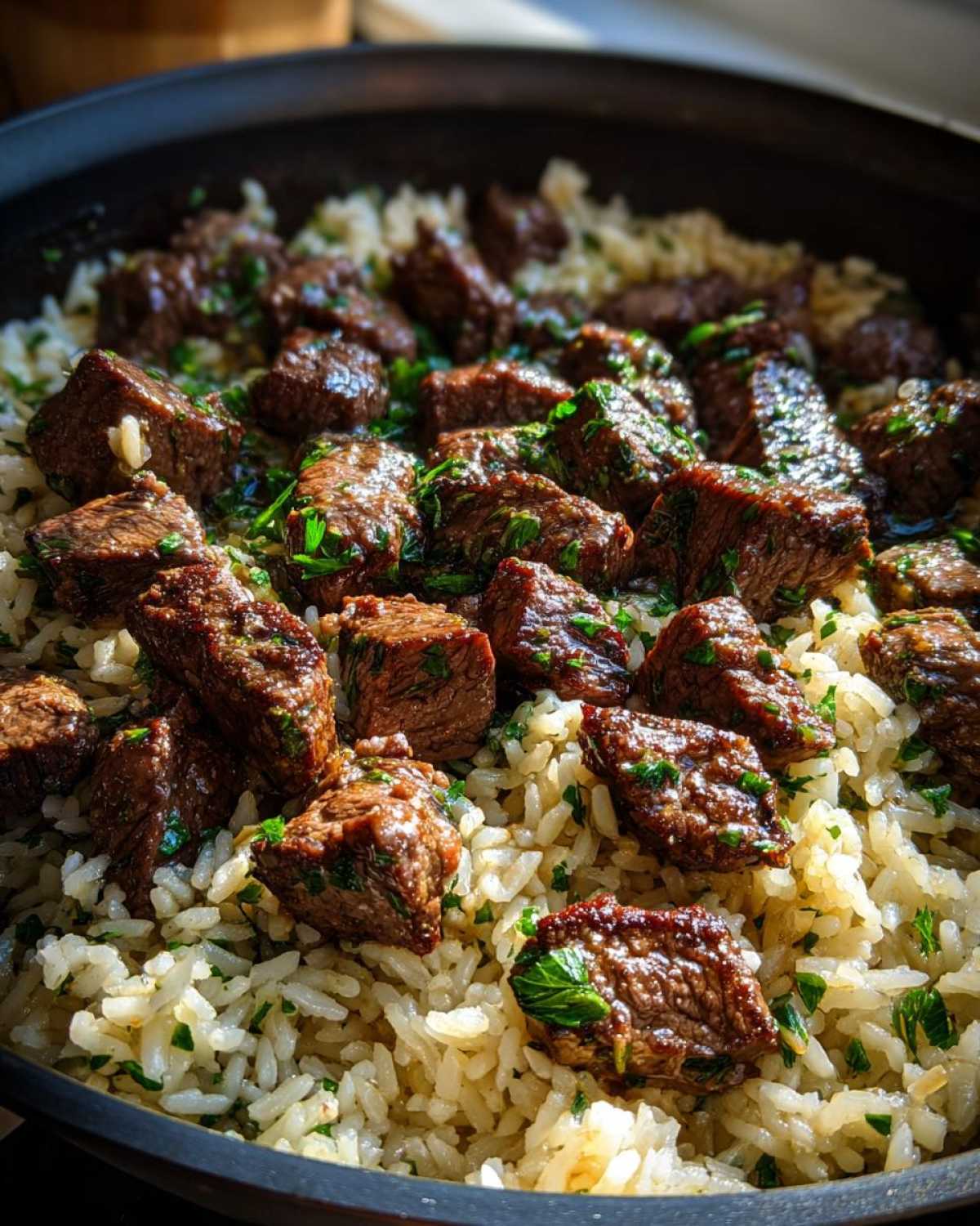 Close-up of juicy steak bites mixed with seasoned rice in a skillet, highlighting the Garlic Butter Steak and Rice Skillet Dinner.