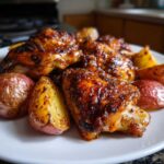 Close-up of glazed, baked chicken pieces served with roasted red potatoes from the Honey Mustard Chicken Bake with Potatoes.